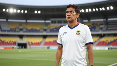 A 35-year-old Ecuadorian coach, wearing a white jersey with a blue collar, standing in the middle of the Yokohama...