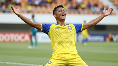 A sweating, ecstatic, 28-year-old Gualaceo midfielder, in a plain yellow shirt with blue sleeves, made of...