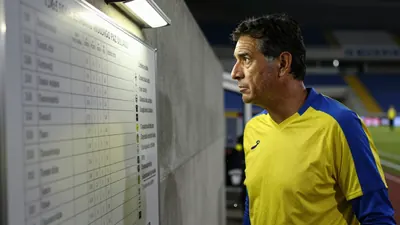 A 35-year-old Ecuador head coach candidate, dressed in a plain yellow and blue polyester training top, stands in the...